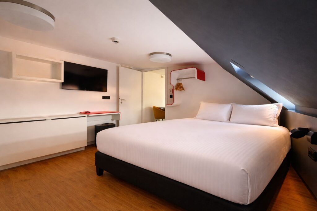 Chambre familiale 6 personnes avec deux lits simples orange et salle de bain, groupe famille Strasbourg