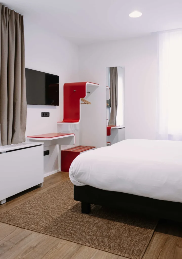 Familienzimmer für 6 Gäste im ClapClap Hotel Straßburg mit Bett, rotem Designmobiliar, Wand-TV und Parkett