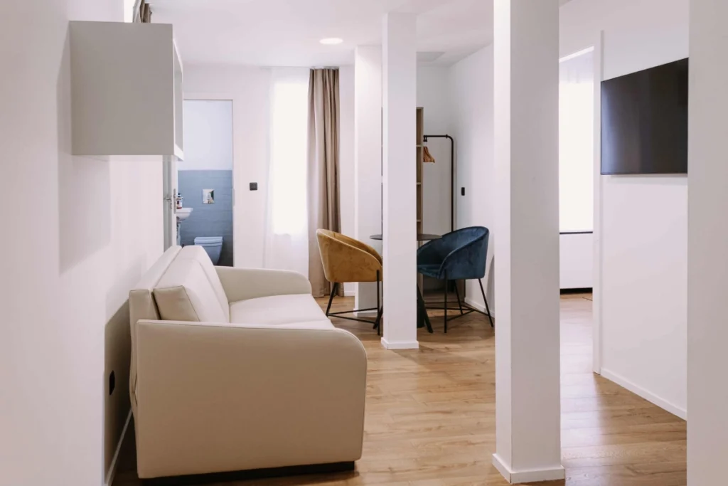 Chambre Famille 6 personnes du ClapClap Hôtel Strasbourg avec canapé, fauteuils, TV murale, salle de bain et parquet