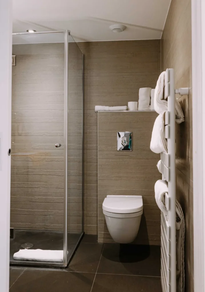 Salle de bain de la chambre Famille 6 personnes du ClapClap Hôtel Strasbourg avec douche vitrée, WC suspendu et sèche-serviettes
