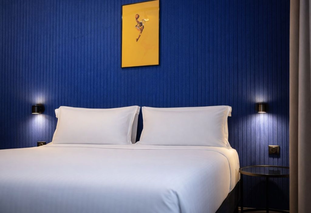 Lit double avec tête de lit bleue et appliques noires, chambre double du ClapClap Hotel à Strasbourg