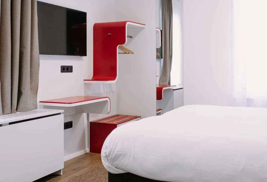 Familienzimmer für 6 Gäste im ClapClap Hotel Straßburg mit Bett, rotem Designmobiliar, Wand-TV und Parkett