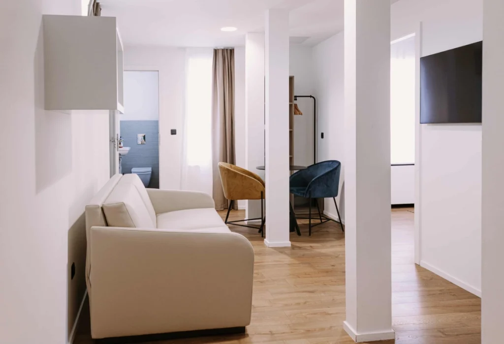 Chambre Famille 6 personnes du ClapClap Hôtel Strasbourg avec canapé, fauteuils, TV murale, salle de bain et parquet