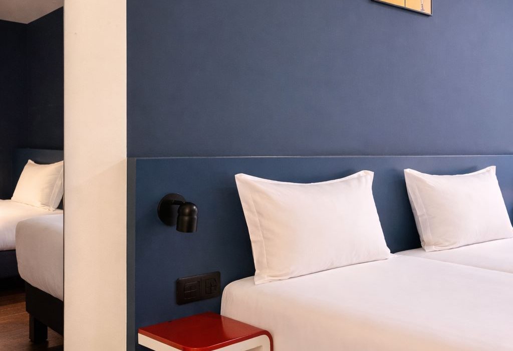 Tête de lit bleu nuit avec affiche Kill Bill, tablette de chevet rouge, chambre triple mansardée ClapClap Strasbourg