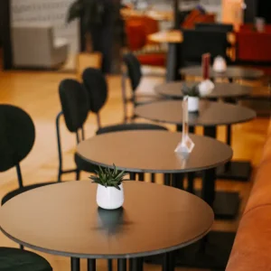 Intérieur du ClapShow au ClapClap Hôtel Strasbourg : tables rondes, banquette orange et décor contemporain
