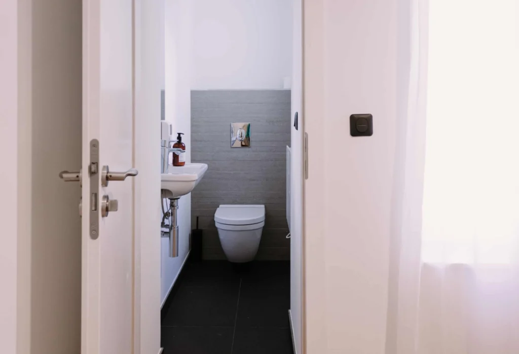 WC du ClapClap Hôtel Strasbourg avec lavabo, carrelage gris et sol noir